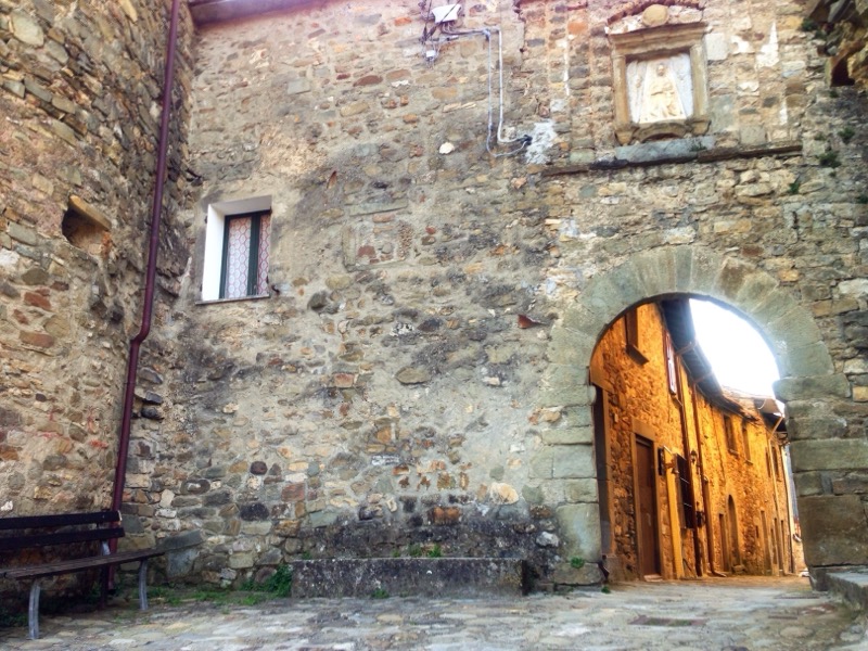 The little stone square and the village entrance arch