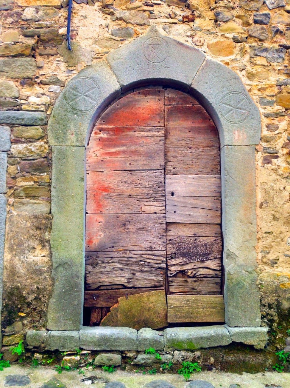Un portale in arenaria del borgo di Castevoli, ad arco, con la data 1664 incisa nella lunetta